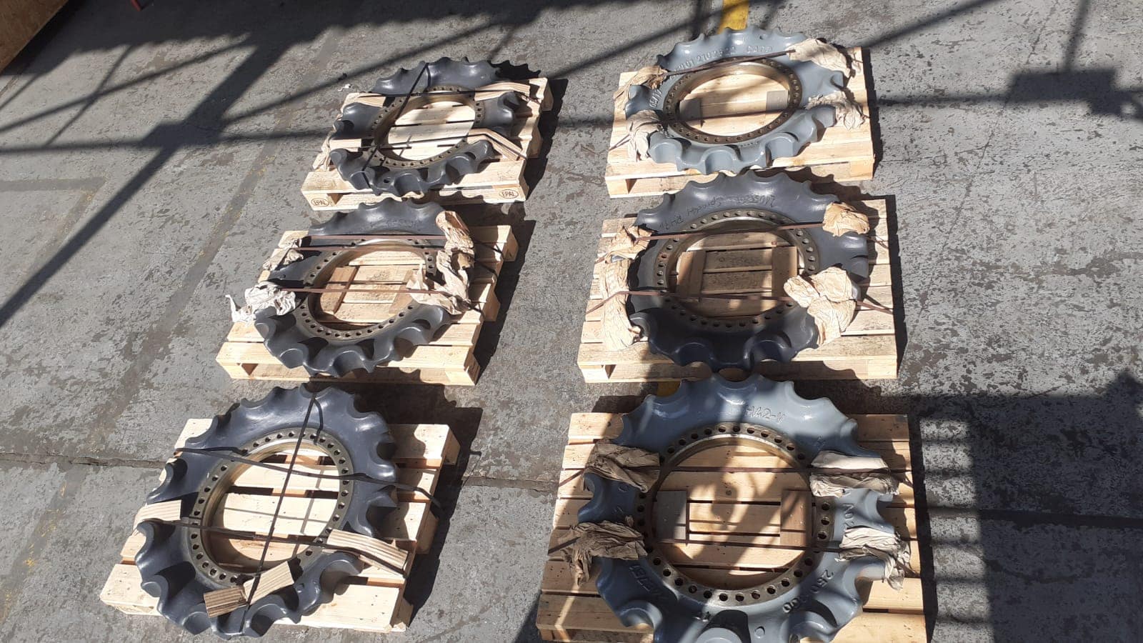 Six sprockets for O&K RH40 excavator, mounted on wooden pallets.