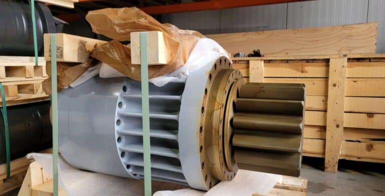 Hochpräzises Maschinenteil, Industriekomponente, in Lagerung auf Holzpalette.