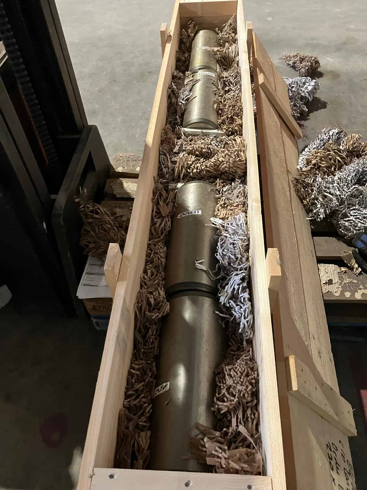 Heavy machinery component in wooden crate for transport.